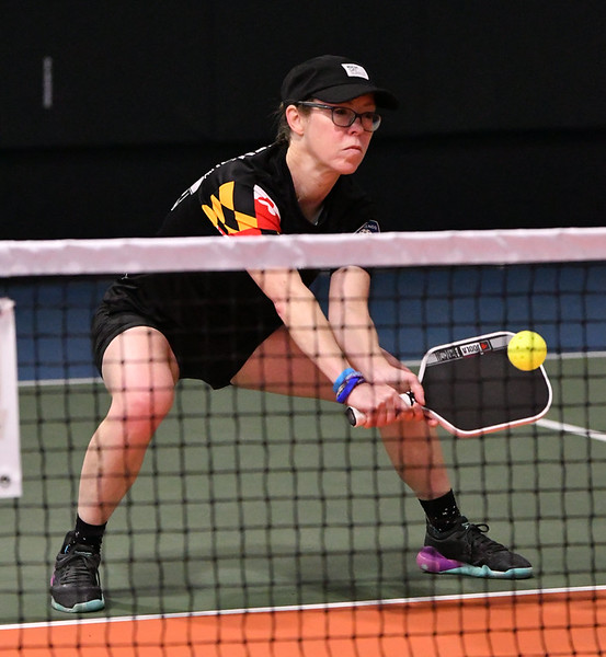 Rachel Rhoney on court in a ready stance, paddle held in both hands as a ball comes toward her